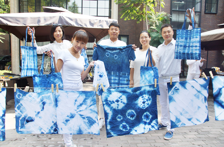 锦连环成员手举亲手制作的蓝白扎染作品合影,展示扎染成果