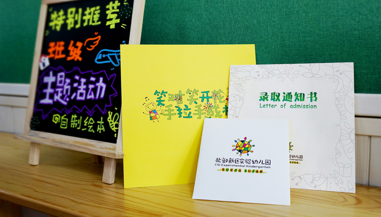 北京市海淀区北部新区实验幼儿园绿黄录取通知书置于黑板前，趣味活动主题设计