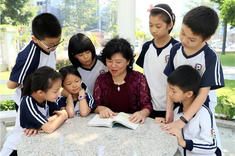 博立雅外国语学校师生共读场景 教师与穿校服学生