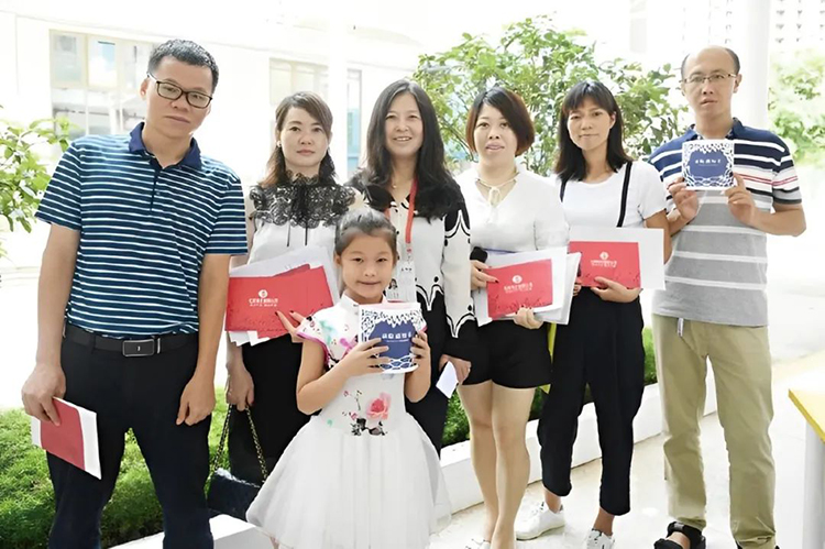 红树林外国语小学新生与家长手持录取通知书合影