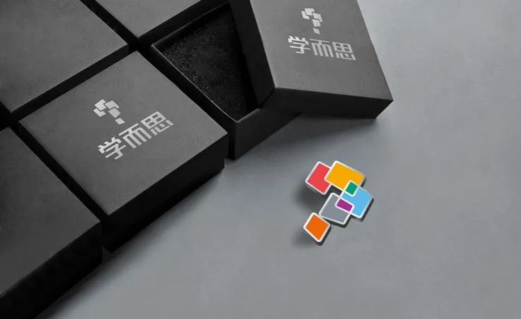 印有学而思logo的黑色礼盒与彩色拼图碎片，教育品牌包装与符号应用设计