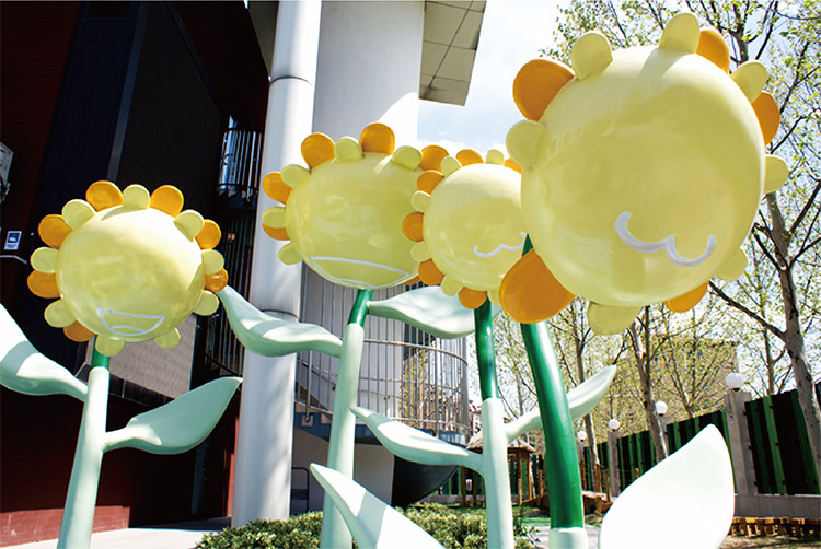 北部新区实验幼儿园操场上的黄色葵花雕塑装置实景，葵花森林校园景观特色
