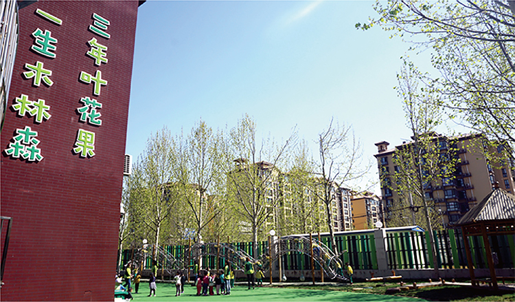 北部新区实验幼儿园园所建筑实景，红墙三年叶花果一生木林森字样与操场，校园文化