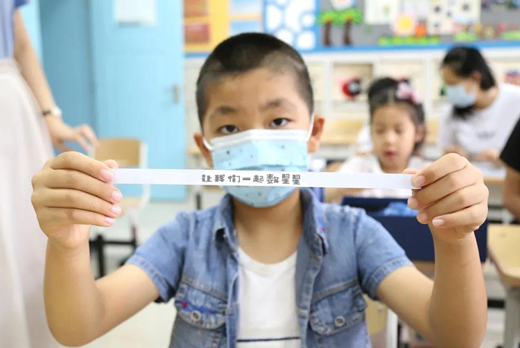 灯市口小学男孩手持星际通行证纸条的照片，星空主题文创应用场景