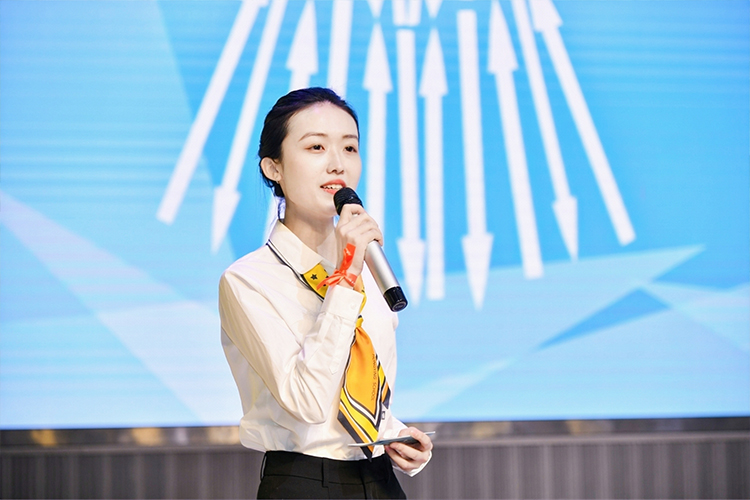 女演讲者在舞台上分享的照片，学校文化建设主题演讲现场