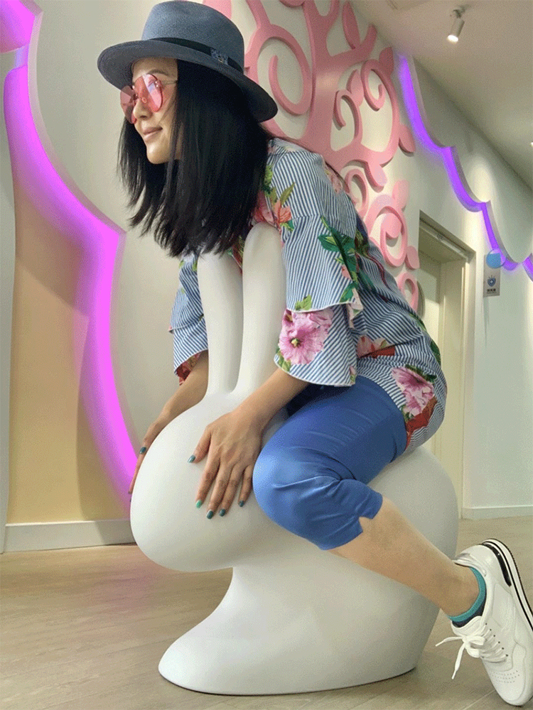 恩济里幼儿园园所环境设计，师生坐在蘑菇造型座椅的彩色走廊场景