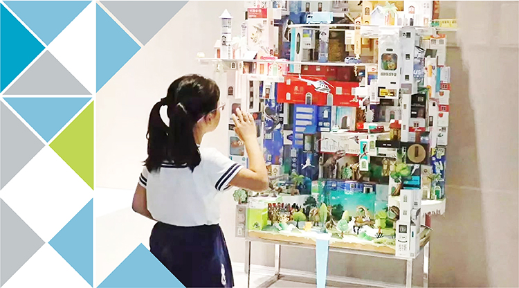 学生在贴满纸艺作品的展墙前驻足观看，锦连环校园文化纸艺展现场