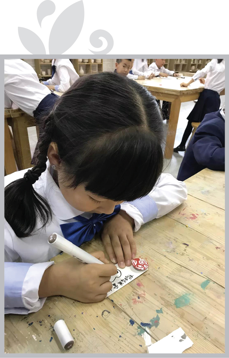 新英才学校学生低头专注手工创作实景，锦连环学校文化建设