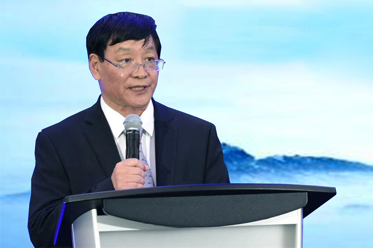 男性嘉宾身着蓝色西装在讲台演讲，中国教育报校长大会现场