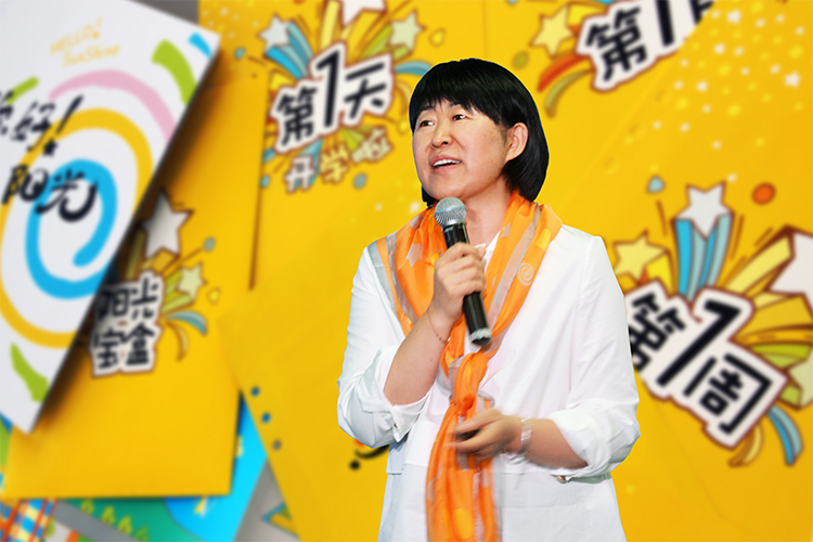 女性嘉宾在彩色舞台手持话筒演讲，2020中国教育报校长大会现场