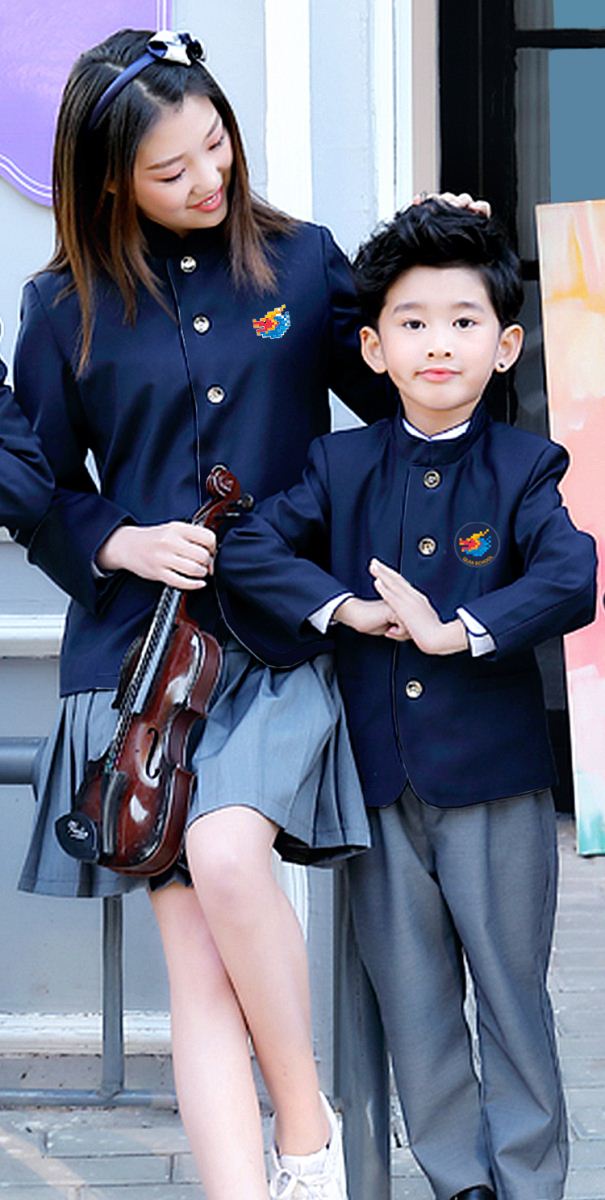上师大附属郑州启佳学校藏青色校服展示，两名学生身着新校服在校园合影，体现校园文化建设