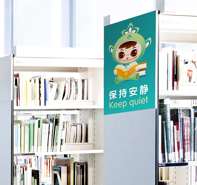 北医附小图书馆书架旁摆放吉祥物立牌，吉祥物IP形象融入校园阅读空间应用