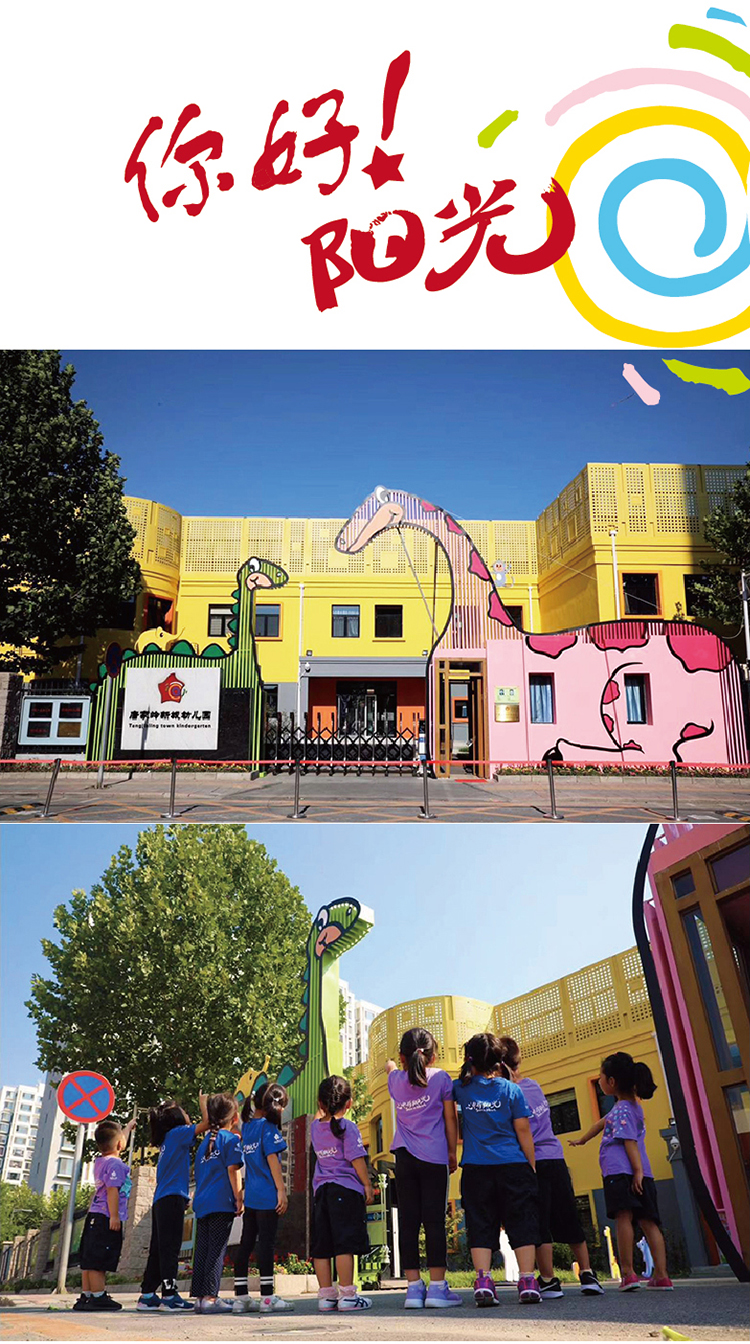 北京市海淀区唐家岭新城幼儿园黄色园舍大门，两只高大恐龙造型雕塑，孩子们仰望，校园文化环境建设实景