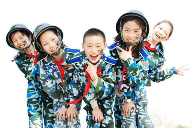 育鹰小学学生身着迷彩服开心合影，展现少年军校朝气风貌