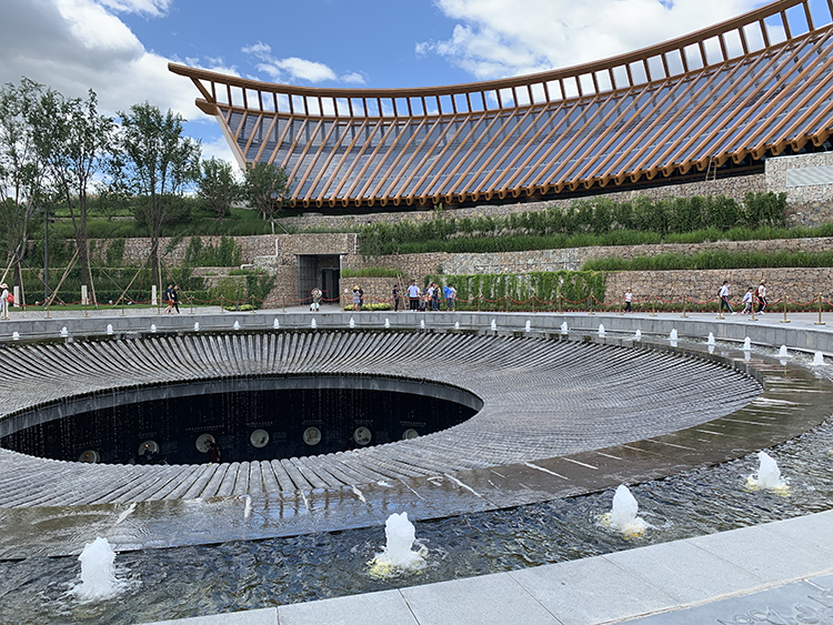世园会环形屋檐场馆与下沉式庭院,弧形建筑环抱中心水景,造型舒展大气