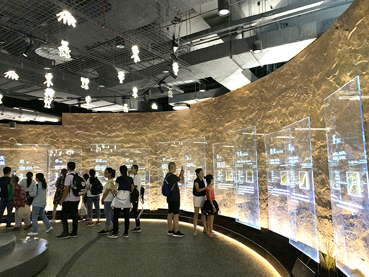 世园会植物馆金色镜面展厅,游客穿行其间参观,光影流转的沉浸式空间