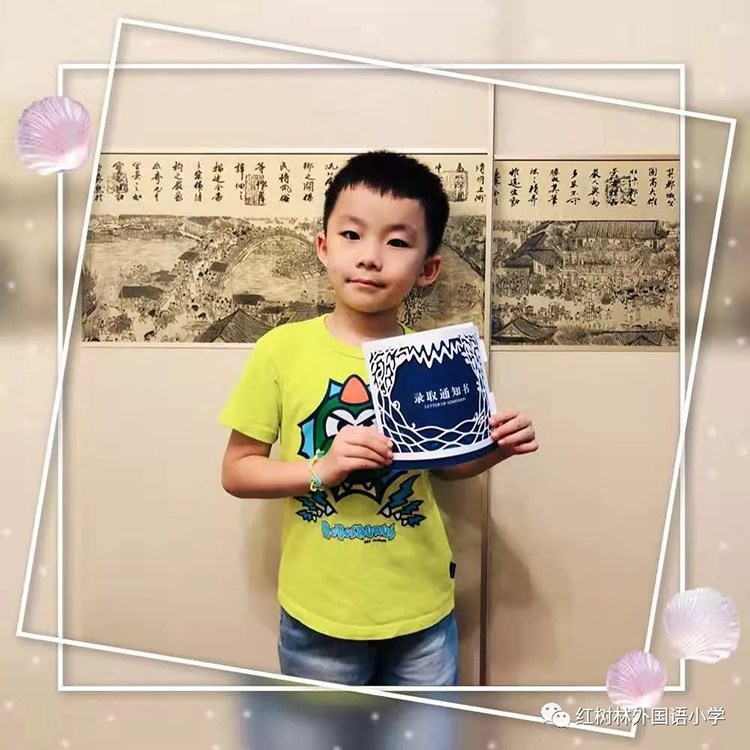 一名男孩手举红树林外国语小学镂空录取通知书留影