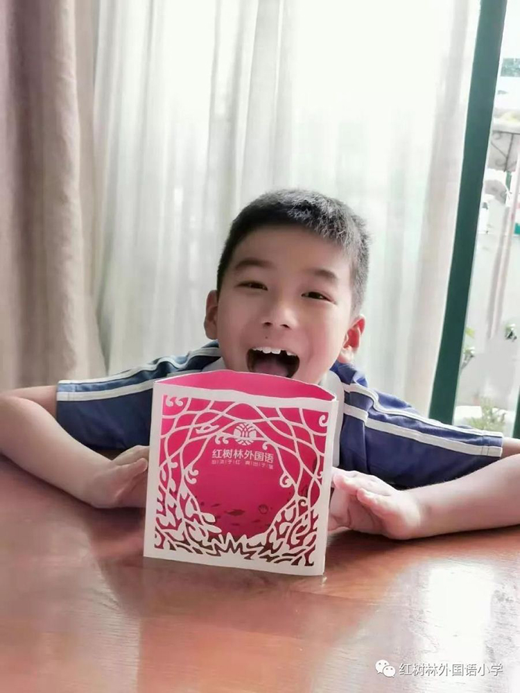 一名男孩手举红树林外国语小学红色录取通知书微笑
