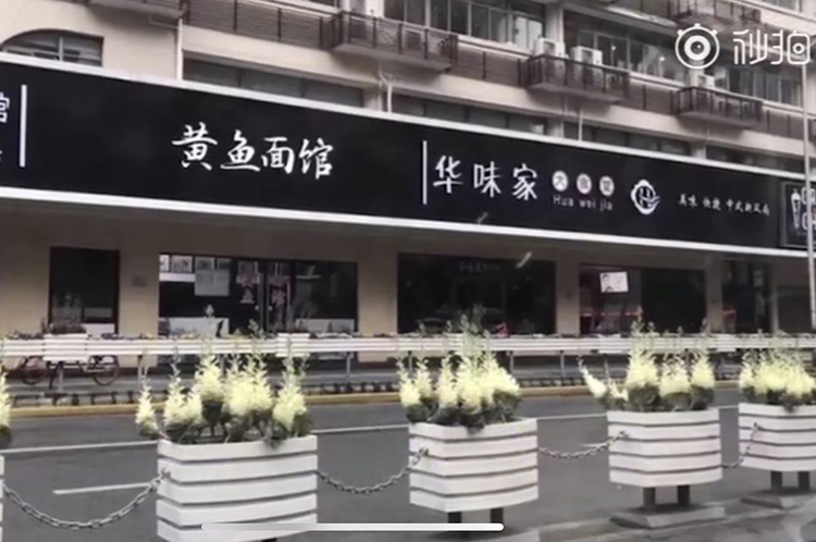 黑白照片中上海街头店铺统一黑底白字招牌黄鱼面馆华味家，引发汉字招牌审美讨论