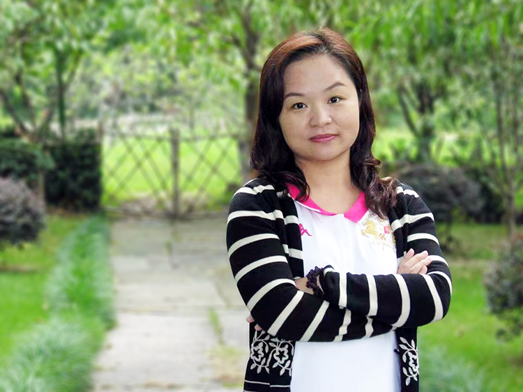 荔湾区青少年宫一位女教师在户外环境中双臂交叉的肖像照片，呈现项目教育者形象