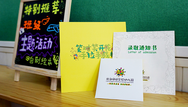 红英小学黄绿色系录取通知书与黑板创意陈列，融入笑对笑开花手拉手成林文化主题