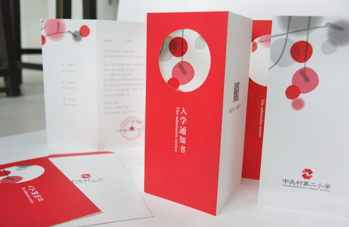 红色入学通知书展开呈现圆形镂空创意设计，层叠折页传递喜庆精致的校园品牌质感