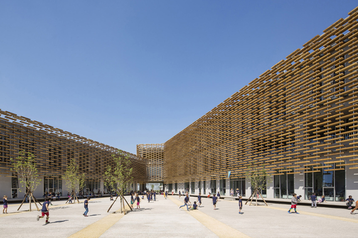 北京法国国际学校木格栅立面建筑外景，原木隔栅环绕校园广场，体现学校环境建设的灵动与节能环保理念