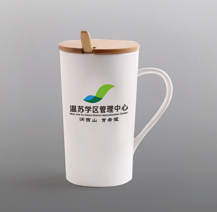 温泉苏家坨学区管理中心品牌物料应用，白色马克杯印有绿色山形学区标识，展现VI系统设计