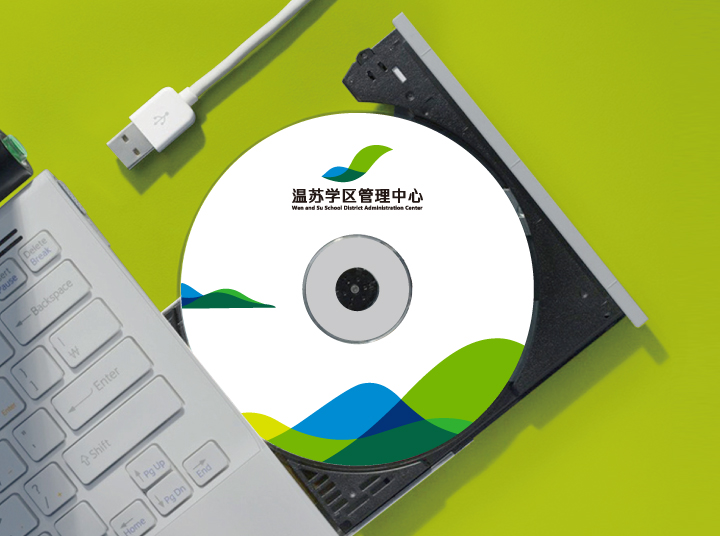 温泉苏家坨学区管理中心VI光盘应用，绿色背景中光盘与键盘印有学区标识，体现教育品牌设计延展