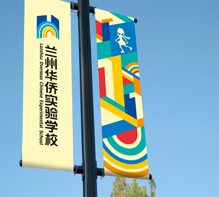 印有兰州华侨实验学校校徽的彩色道旗悬挂于路灯杆，锦连环校园环境导视设计
