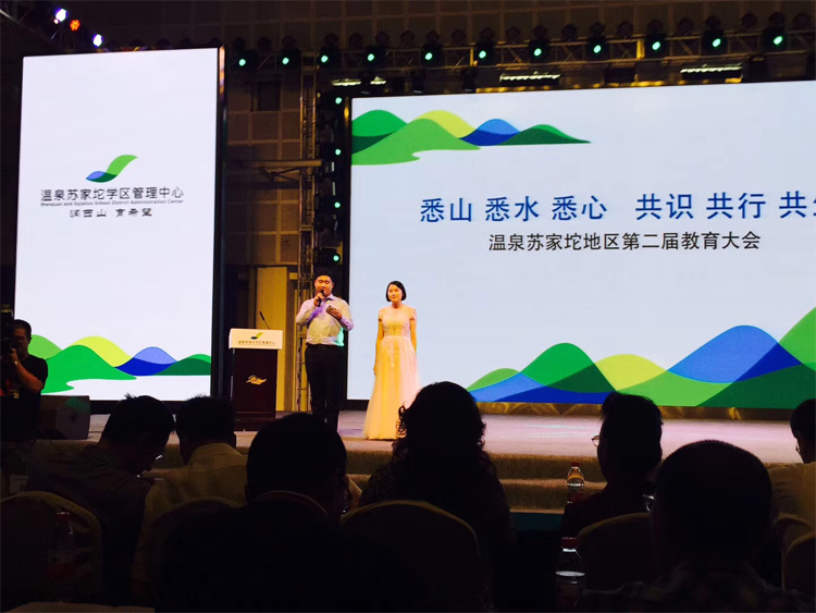 温泉苏家坨教育大会舞台主持人发言，大屏显示大会主题标语，锦连环活动策划主视觉