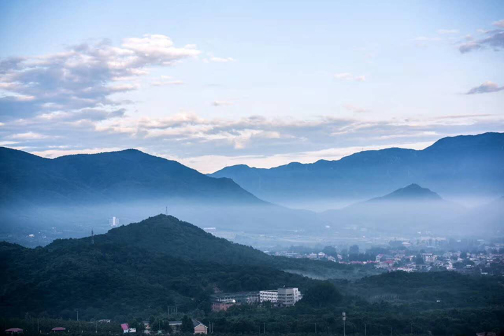 北京西山山脉云雾缭绕的实景照片，温泉苏家坨学区依托西山办学的地域文化背景