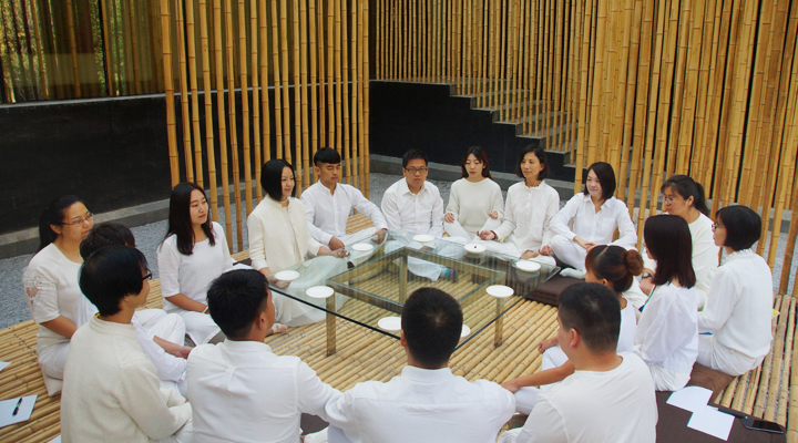 锦连环小伙伴身着白衣围坐竹屋中交流分享,感受建筑与文化之美