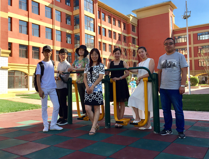 锦连环设计团队在兰州华侨实验学校彩色操场与师生合影，实地走访校园