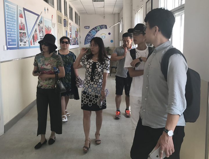 锦连环设计团队在校领导陪同下参观校园文化展廊，了解学校发展现状