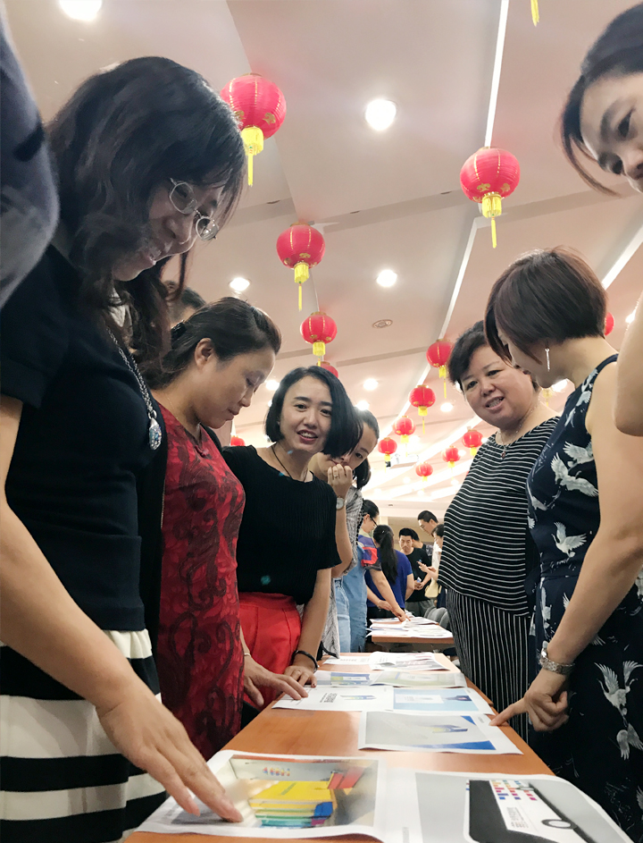 兰州华侨实验学校教师围坐桌前交流互动，参与品牌文化主题活动