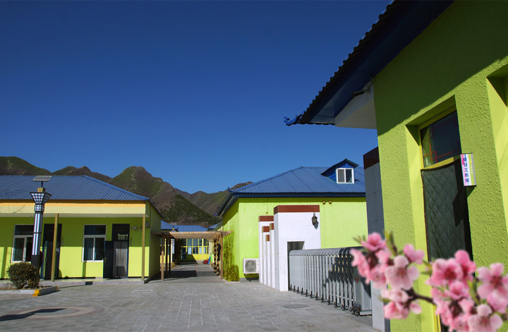 昌平区桃洼学校校园建筑外景照片,彩色墙面教学楼与远山构成校园环境