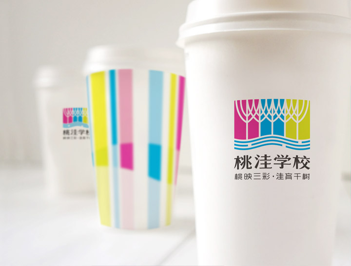 印有桃洼学校标识与彩色条纹的纸杯,校园品牌视觉在文创周边上的应用