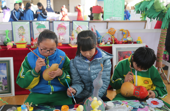 昌平区桃洼学校学生在书香文化节上手绘葫芦，展现校园特色课程与学校文化建设成果