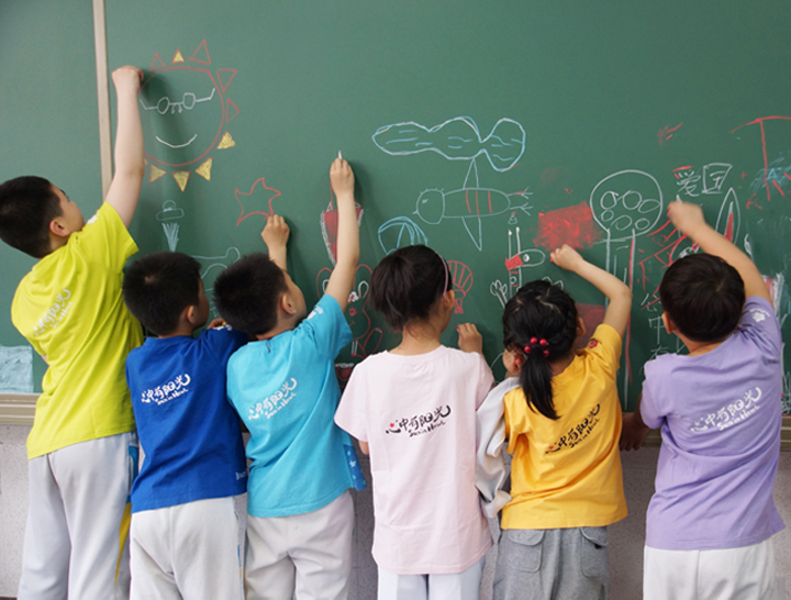 红英小学学生在黑板前书写绘画的活动场景，展现阳光活力的校园文化氛围