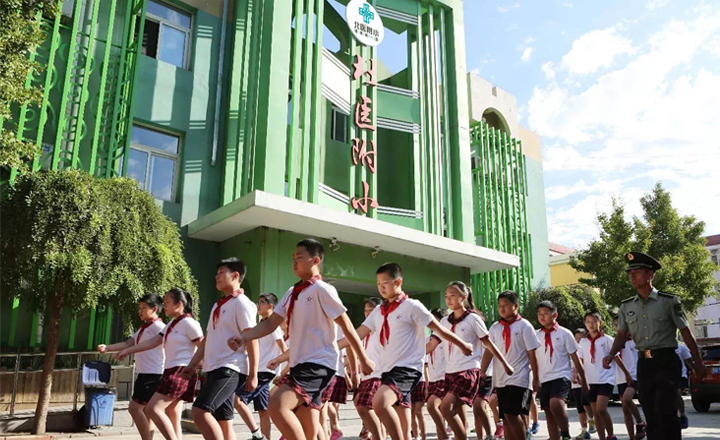 北医附小绿色教学楼前学生列队合影实景,校园环境建设展示,锦连环学校特色定位案例