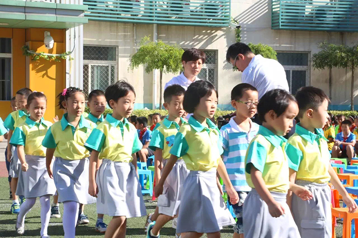 北医附小学生身着绿色校服在户外列队参加活动,校园生活实景,锦连环教育品牌案例