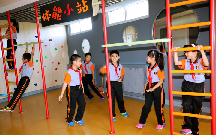 石油二小室内活动空间，学生在书架墙前排队，锦连环校园文化建设案例