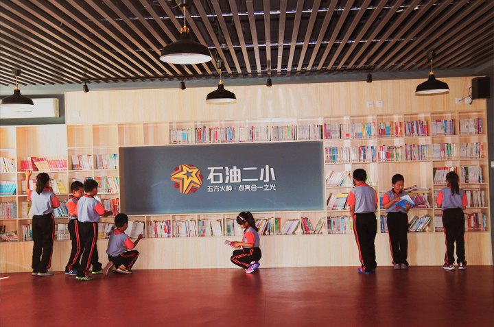 石油二小室内大厅空间，品牌展示墙与开阔场地，锦连环校园文化建设案例