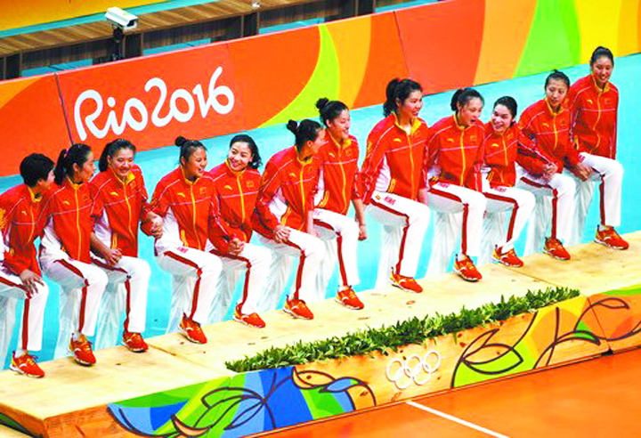 里约奥运会运动员身着橙红色品牌队服在领奖台就座，Rio2016品牌背板
