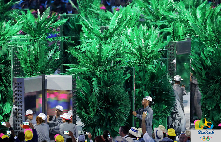里约奥运开幕式绿色植物景观，舞台绿树环绕，呼应环保主题品牌设计