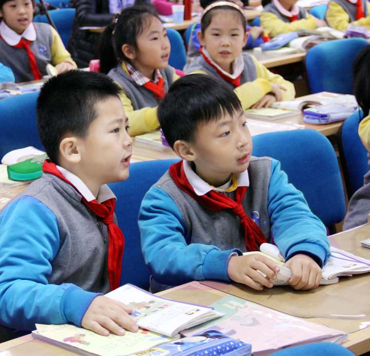 教室内身着蓝色校服佩戴红领巾的学生认真学习场景，丰合五小校园