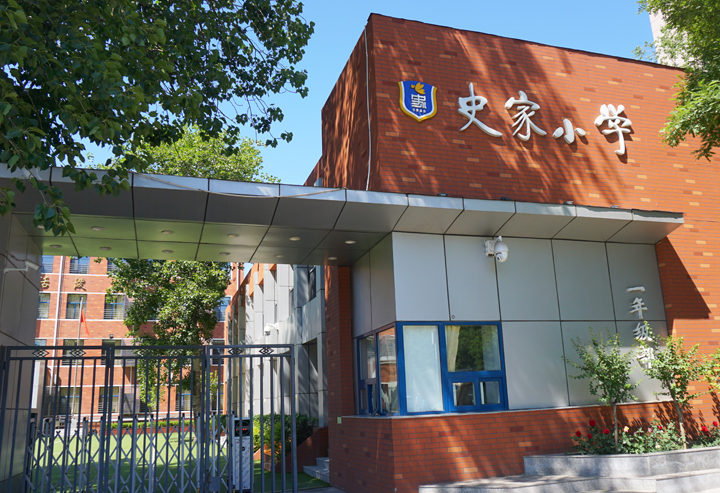 史家小学红砖教学楼外景，门口悬挂校牌，锦连环设计课堂走进史家小学校园活动现场