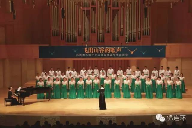大峪中学学生合唱团在音乐厅整齐演出实景，绿色礼服列队歌唱，锦连环校园文化活动