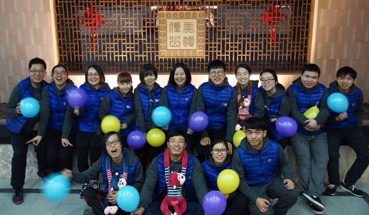 锦连环员工身着蓝衣户外合影，气球装饰增添节日气氛